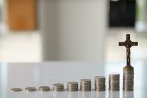 ascending pile of coins with a cross on top is the concept of life insurance for health care and accumulation of benefits for the family after death. The concept of health insurance and life insurance photo