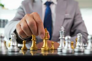 Young businessman planning winning chess move in game of chess representing successful and victorious business path. chess concept representing strategic business strategy to achieve victory. photo