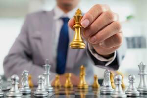 Young businessman planning winning chess move in game of chess representing successful and victorious business path. chess concept representing strategic business strategy to achieve victory. photo