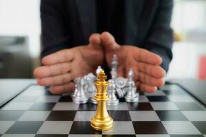 Young businessman planning winning chess move in game of chess representing successful and victorious business path. chess concept representing strategic business strategy to achieve victory. photo
