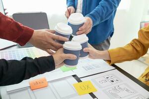 programadores y ui ux diseñadores tener taza de caliente café juntos en diseño estudio durante rompe para cerebro impulsando café aumentar antes de comenzando otro redondo. diseño equipo café descanso concepto foto