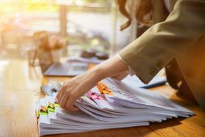 stack of documents on secretary desk were prepared It is legal document for real estate buyers to be used as evidence of possession. stacked papers were placed on the table awaiting examination. photo