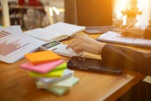 An accountant is using a calculator to accurately calculate the income and expenses and is using the calculator to review the company investment results and profits Copy Space for text photo