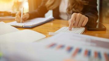 An accountant is using a calculator to accurately calculate the income and expenses and is using the calculator to review the company investment results and profits Copy Space for text photo