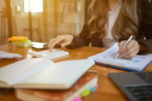 An accountant is using a calculator to accurately calculate the income and expenses and is using the calculator to review the company investment results and profits Copy Space for text photo