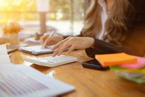 An accountant is using a calculator to accurately calculate the income and expenses and is using the calculator to review the company investment results and profits Copy Space for text photo