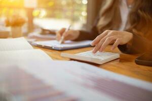 An accountant is using a calculator to accurately calculate the income and expenses and is using the calculator to review the company investment results and profits Copy Space for text photo