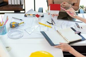 Engineers and designers are discussing the layout of the house and the construction schedule to be completed on schedule. House construction ideas with a team of professional engineers and designers. photo