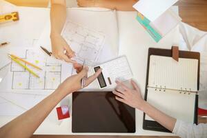 Engineers and designers are discussing the layout of the house and the construction schedule to be completed on schedule. House construction ideas with a team of professional engineers and designers. photo