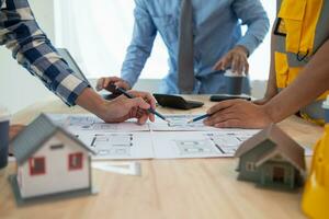 Construction engineers discuss and exchange ideas with architects to improve house plans to meet customer needs. A concept for exchange of design ideas between construction engineers and architects. photo