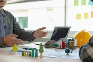 Construction engineers place plans and model homes  on desks in their offices for real estate agents to view the plans they want construction engineers to build on budget and meet client needs. photo