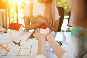 Engineers and designers are discussing the layout of the house and the construction schedule to be completed on schedule. House construction ideas with a team of professional engineers and designers. photo
