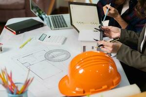 Architects and engineers discuss how to design  housing estate to ensure construction is up to standard and completed on time. team of engineers and architects discuss building design and structure. photo