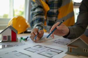 Construction engineers discuss and exchange ideas with architects to improve house plans to meet customer needs. A concept for exchange of design ideas between construction engineers and architects. photo