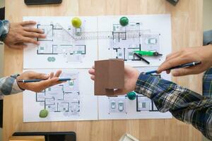 Architects and engineers discuss how to design  housing estate to ensure construction is up to standard and completed on time. team of engineers and architects discuss building design and structure. photo