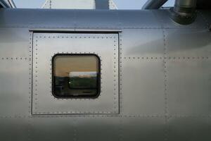 metal wall in background is wall of an airplane fuselage that has been repurposed as residential vehicle. metal wall with metal rivets hold joints together is metal wall of an airplane and copy space photo