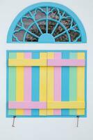 vintage arched wooden windows are painted in beautiful colors and are designed with bright colors on background. Bright rainbow colored windows are design on white background because they are popular. photo