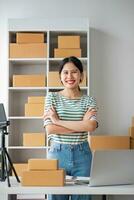 Starting Small business entrepreneur SME freelance, Portrait young woman working at home office, BOX, smartphone, laptop, online, marketing, packaging, delivery, b2b, SME, e-commerce concept. photo