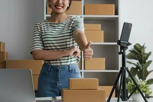 Starting Small business entrepreneur SME freelance, Portrait young woman working at home office, BOX, smartphone, laptop, online, marketing, packaging, delivery, b2b, SME, e-commerce concept. photo