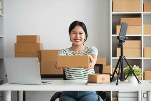 Starting Small business entrepreneur SME freelance, Portrait young woman working at home office, BOX, smartphone, laptop, online, marketing, packaging, delivery, b2b, SME, e-commerce concept. photo