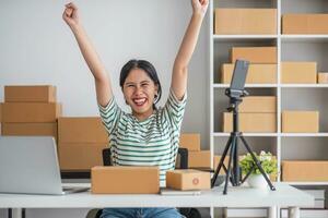 Starting Small business entrepreneur SME freelance, Portrait young woman working at home office, BOX, smartphone, laptop, online, marketing, packaging, delivery, b2b, SME, e-commerce concept. photo