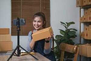 Asian blogger review products and video camera on her phone, sell them online, and showcase her products online on social media. ecommerce business live streaming vlog new normal concept photo