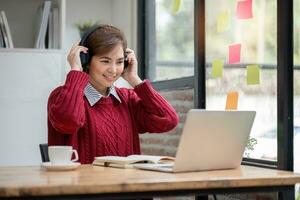 asiático hembra estudiante estudiar en línea en clase, estudiar en línea, vistiendo auriculares, acecho vídeo llamar, zoom, contento asiático hembra aprendizaje idioma en línea con computadora ordenador portátil. foto