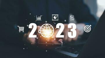 usinessman holds tablets with target and number new year 2023 on the business graph background Innovative new ideas of inspiration from online technology, Changes in new planning, Business Growth photo