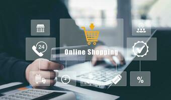 Man using a laptop with typing on a keyboard with online shopping concept, Shopping cart part of the network in hand, Innovation in eCommerce, Online shopping business with selecting shopping cart. photo