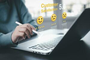 Businessman pressing smile on laptop keyboard customer service, evaluation concept,rating to service experience on online application, Customer review satisfaction feedback survey,Negative feedback photo