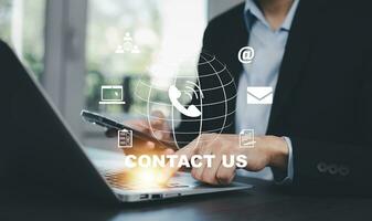 Communication and Contact us or Customer support hotline people connect. Hand using a laptop and touching on virtual screen contact icons, email and address, live chat with internet wifi. photo