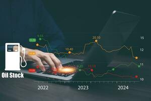 Oil energy graph new year 2024, impact on the economy concept, Man use a laptop with the chart with the indicator on the oil price slide at gas station, fluctuations in oil prices and exchange trade. photo