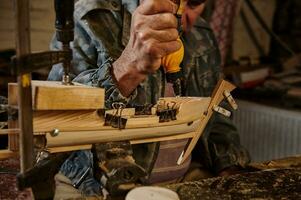artesano pega de madera detalles en un velero en su propio taller. carpintero en acción, estilos de vida, pasatiempo conceptos foto