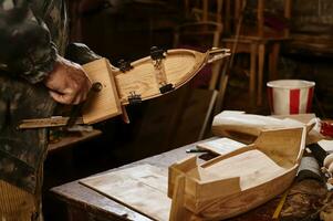 Wooden models of ships on the carpenter's desk against the background of a working craftsman photo