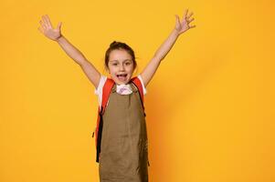 auténtico retrato de un Chica de escuela en casual tener puesto, expresando positivo emociones, aislado terminado naranja estudio antecedentes foto