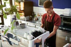 Barista preparing coffee on professional steam coffee machine behind a bar counter in cafe photo