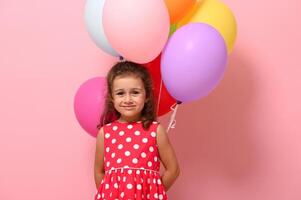 Beautiful baby girl, smiling looking at camera, isolated over pink background with copy space. Concept of happy childhood, International Woman's and Children Protection Days. Celebrations, events photo