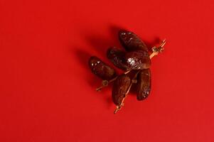 Flat lay with a branch of fresh tasty sweet dates for breakfast after interruption and fasting in Ramadan photo