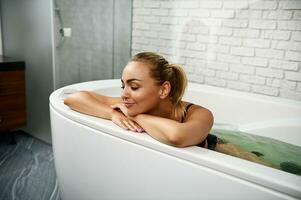 Young woman relaxes with closed eyes while receiving wellness procedures in SPA wellness capsule. photo