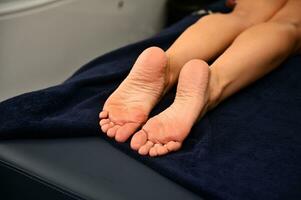 Woman's legs lying on a massage table in wellness spa resort photo