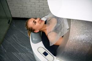 A young woman in spa capsule receiving spa treatments for weight loss, anti-cellulite, anti-aging, massage and stress relief. photo