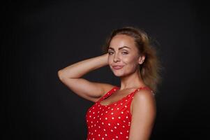 Attractive beautiful 30 years old Caucasian woman in red swimsuit isolated over black background with copy ad space. photo