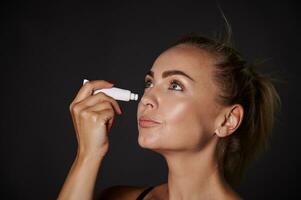 de cerca retrato de un hermoso medio Envejecido mujer aplicando anti hinchazón anti arrugas hidratante debajo ojos. juventud concepto y prevención de primero señales de envejecimiento proceso. foto