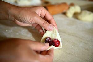 Soft focus on pastry chef hand sculpting cherry dumplings. Process of cooking dumplings step by step. Close-up, food background photo