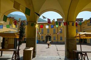 patio callejón en medieval italiano ciudad, decorado con vistoso banderas para un festival. viaje y turismo concepto foto