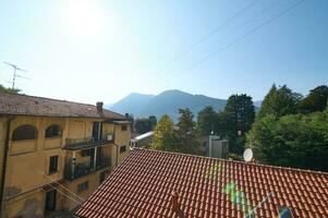 Rooftop tiles in medieval Canzo, Lombardy, Italy, against Italian Alps background. Copy advertising space. photo