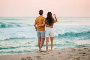 pareja joven en las vacaciones de playa en florida al atardecer foto