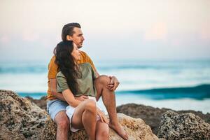 Young couple on the beach summer vacation. Happy man and woman look at the sea photo