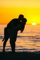 pareja romántica en la playa al atardecer colorido en el fondo foto