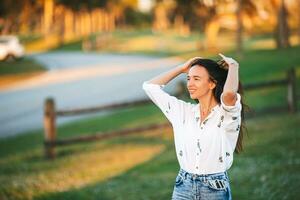 Portrait of happy young woman outdoor in the park at sunset photo